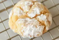 A stack of Pumpkin Butter Cookies coated in powdered sugar, showing a soft, thick, gooey texture for a cozy fall dessert.