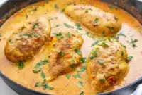 Close-up of Spicy Brazilian Coconut Chicken in creamy coconut-chili sauce with lime and cilantro, served over steamed rice.