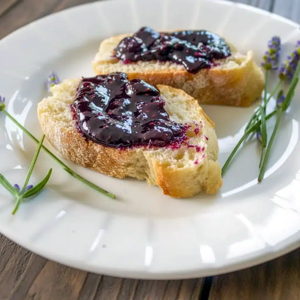 Freshly made Blueberry & Lavender Jam served in a glass jar, shown as a lovely Lavender Jam Recipe with bright fruit and a soft floral touch.