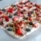 A sheet of Frozen Yogurt Bark topped with berries and nuts for a refreshing, crunchy, and colorful dessert.