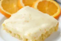 A square of Orange Brownies topped with creamy frosting, styled as one of the best Dessert Recipes With Orange Juice for a bright citrus treat.