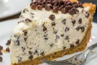 A creamy slice of Chocolate Chip Cannoli Pie with a smooth Cannoli Pie With Mascarpone filling and chocolate chips on top.