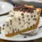 A creamy slice of Chocolate Chip Cannoli Pie with a smooth Cannoli Pie With Mascarpone filling and chocolate chips on top.