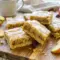 Tray of Maple Glazed Apple Blondies with a rich maple drizzle and soft apple filling, styled as Apple Blondies With Maple Glaze.
