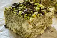 Pistachio and White Chocolate Rice Krispies Treats are styled as Pistachio Topped Treats with chopped nuts and a rich chocolate drizzle.