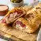 Reuben Stromboli baked golden and sliced for a cheesy Reuben Roll dinner with corned beef, Swiss, and tangy dressing.