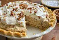 A slice of Pecan Cream Pie on a holiday plate, styled as Pies With Pecan Crust for a festive Thanksgiving dessert.