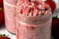 A jar of Strawberries and Cream Overnight Oats with fresh berries on top, a bright Overnight Oats Recipe Strawberry for busy mornings.