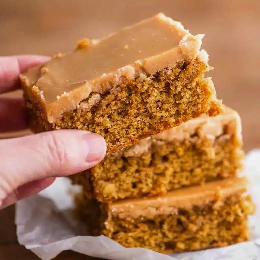 Close-up of a tender crumb studded with chopped walnuts under thick coffee frosting in a homemade Coffee Fudge Traybake.