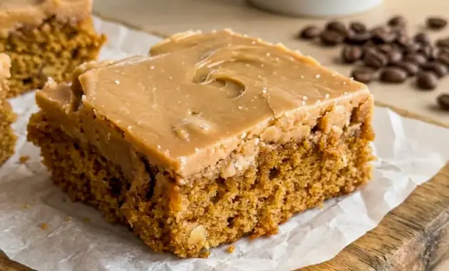 Square of moist coffee walnut cake topped with glossy fudge icing, a perfect Coffee Fudge Traybake cut fresh from the 9x13 pan.